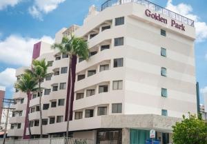 萨尔瓦多Hotel Golden Park Salvador的一座白色的建筑,前面有棕榈树