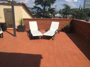 塞斯托-菲奥伦蒂诺劳拉公寓的砖砌庭院里两把白色椅子
