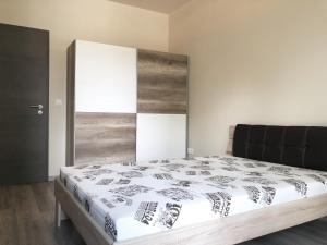 佩奇Exclusive Home的一间卧室配有一张大床和木制床头板