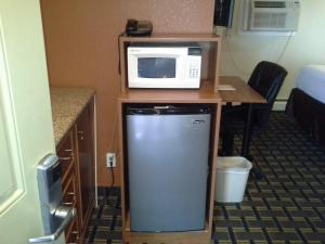 托纳万达托纳旺达经济旅馆的冰箱的桌子上配有微波炉