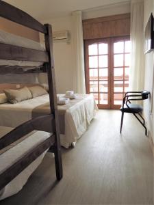维拉卡洛斯帕兹Casa Piedra Hotel的一间卧室设有两张双层床和一扇窗户。