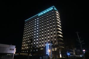 仙台仙台东区丽亚特经济型酒店的一座高大的建筑,晚上有标志