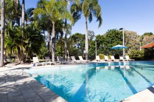 拜伦湾绿洲公寓特里托普住宅的一个带椅子的游泳池,棕榈树