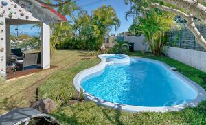 勒唐蓬Villa Ti caz do miel avec piscine et bassin de détente à remous au Tampon pour 8 personnes的一座房子的院子内的游泳池