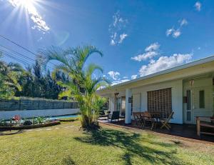 勒唐蓬Villa Ti caz do miel avec piscine et bassin de détente à remous au Tampon pour 8 personnes的一座带庭院和棕榈树的房子