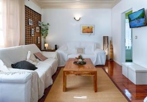 勒唐蓬Villa Ti caz do miel avec piscine et bassin de détente à remous au Tampon pour 8 personnes的客厅配有白色沙发和茶几