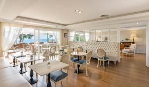 雅弗郎其Hotel BlauMar Llafranc的餐厅设有桌椅和窗户。