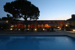 圣雷米普罗旺斯梵高酒店的一座游泳池,在晚上在建筑物前