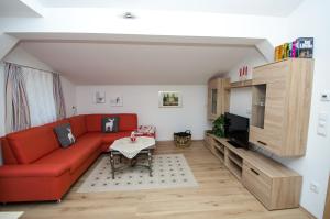 维尔德科格尔山麓布兰贝格Haus Lercher的客厅配有红色沙发和电视