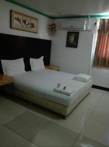 卡利博Asia Novo Boutique Hotel - Kalibo的一间卧室配有一张床和一张桌子