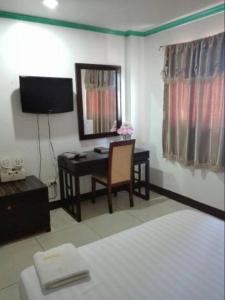 卡利博Asia Novo Boutique Hotel - Kalibo的一间卧室配有书桌和一张带镜子的床