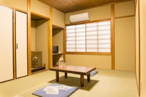 京都Ryokan Hinomoto Kyoto Kawaramachi的客厅配有桌子和窗户