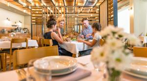 波兰尼卡-兹德鲁伊Hotel Polanica Resort & Spa的一群坐在餐厅桌子上的人