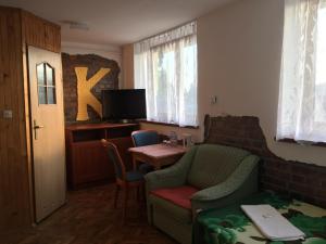 OrawkauKazika的客厅配有桌椅和电视。