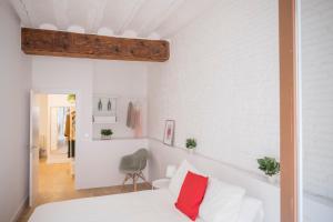 潘普洛纳El Mirador de la Cuesta de Santo Domingo的卧室拥有白色的墙壁,配有一张带红色枕头的床。