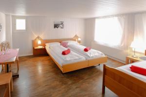 Alpnach阿尔卑纳赫兰德斯托付施鲁塞尔宾馆的一间卧室配有两张带红色枕头的床。