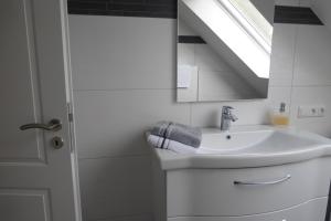 罗埃特根Ferienwohnung am Eifelsteig的白色的浴室设有水槽和窗户。