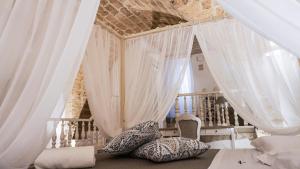 阿尔塔穆拉L'IMPERATORE Relax & Charme的卧室配有白色窗帘和枕头,位于地板上