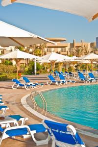 艾因苏赫纳Grand Ocean El Sokhna的一个带蓝色椅子和遮阳伞的游泳池