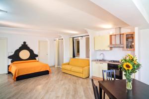 陶尔米纳Medea Residence appartamenti vacanze的一间卧室配有一张床铺和一张桌子,还设有一间厨房