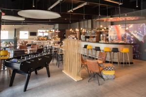富恩拉夫拉达宜必思马德里丰拉夫拉达酒店的餐厅设有酒吧,配有桌椅