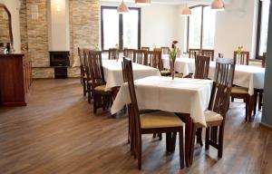 沃尔托普Pensiunea Panoramic的用餐室配有白色的桌子和木椅