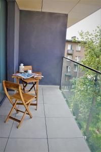 克拉科夫Apartamenty Retmana的阳台配有桌椅。