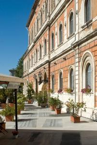佩鲁贾艾瑞斯酒店的前面有盆栽植物的大砖砌建筑