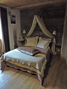 拜兰特里A la Bouge'Hôtes的一间卧室配有一张带天蓬的大床