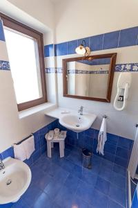 帕图马塞里亚琉璃普尔克拉酒店的蓝色瓷砖浴室设有水槽和镜子