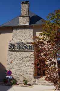 Saint-YbardHôtel Saint-Roch, The Originals Relais的砖砌的建筑,旁边标有标志