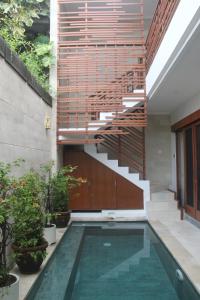 塞米亚克Green Studio Apartment Seminyak的一座带游泳池和楼梯的房屋