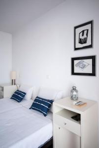 卡拉泽达丹西昂伊什七书之家旅馆的白色的床、蓝色枕头和白色桌子