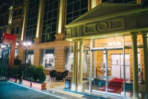 巴库Emerald Suite Hotel的夜间在建筑物前的商店