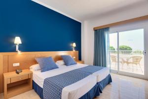 厄尔-汝姆披多Garden Playanatural - Adults Only的一间卧室配有一张蓝色墙壁的床