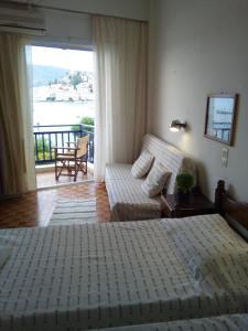 加拉塔斯Bissias Guest House的一间卧室配有一张床和一张沙发,并设有一个阳台
