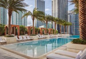 迈阿密布里克尔SLS勒克斯酒店的一座带椅子和棕榈树的游泳池