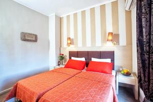 卡斯托里亚安纳斯塔希亚酒店的一间卧室配有红色的床和两个红色枕头
