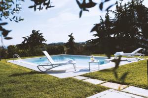 AntignanoMoonfrà的庭院内一个带两把躺椅的游泳池