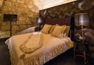 加济安泰普HSVHN Hotel Hışvahan的一间卧室设有一张床和石墙