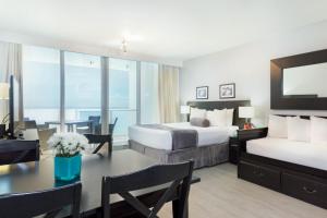 迈阿密海滩新起点迈阿密海滩公寓酒店的酒店客房带两张床、一张桌子和一间餐厅