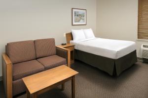 列克星敦WoodSpring Suites Lexington Southeast的酒店客房,配有床和沙发