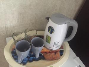 赫梅利尼克Hotel Europe的茶壶和茶杯盘上的杯蛋糕