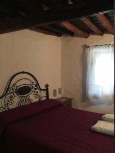 Jubrique卡萨拉蓬特度假屋的一间卧室设有红色的床和窗户。
