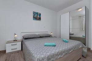 马卡尔斯卡Apartmani R&B Radalj的白色卧室配有床和镜子