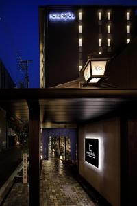 京都京都河原町三条瑞索酒店的两幅晚上与街道相映的建筑物照片