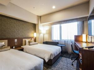 大阪大阪心斋桥由尼森酒店的酒店客房配有两张床和一张书桌