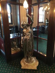 旺阿雷The Kamo Hotel的手持灯具的女人的青铜像