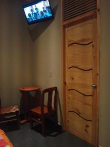 阿雷基帕La Posada Del Misti的一间有门的房间,墙上有一台电视机