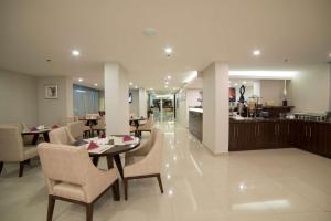达曼Tulip Inn Corniche Dammam的一间带桌椅的用餐室和一间厨房